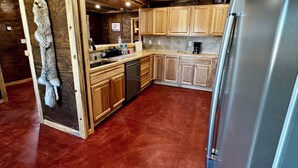 Una cocina con armarios de madera, un refrigerador de acero inoxidable y un lavavajillas.