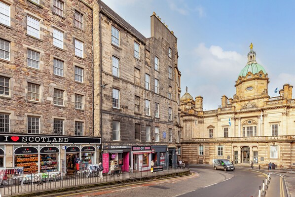 A historic stone building with shops on the ground floor, including a coffee shop and a store named 'Zebra Coffee Co.' - Bank Street Apartment | Royal Mile | Walk to Edinburgh Castle (Edinburgh)
