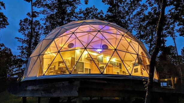 A geodesic dome structure with a kitchen area visible inside.