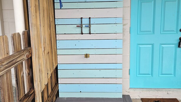 A wooden deck leading to a door with a number '2' and a blue door with a number '5' on it.