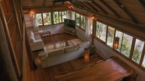 Amplia sala de estar con una mesa de comedor de madera, un sofá y un televisor.