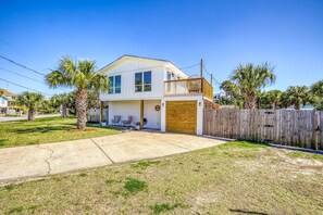 A two-story house with a wooden deck and a garage. - 🌴☀️Private Pool | Backyard Oasis w/ Fireplace | Pet Friendly 🐾 Largo 802 (Pensacola Beach)