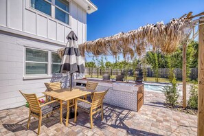 A patio with a wooden table and chairs, a barbecue grill, and a pool. - 🌴☀️Private Pool | Backyard Oasis w/ Fireplace | Pet Friendly 🐾 Largo 802 (Pensacola Beach)