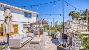 Eine Terrassensitzgruppe mit einer Couch, Sesseln, einem Tisch und einer Pergola.