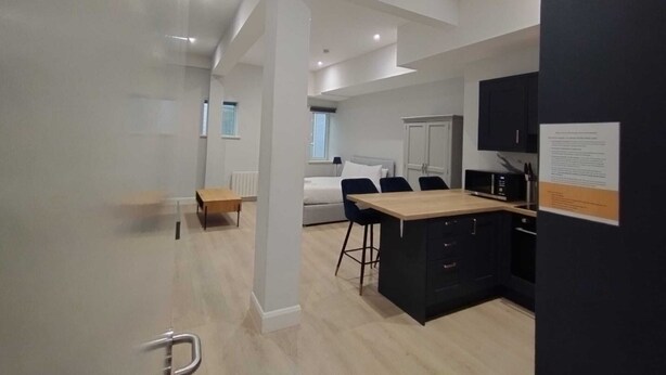 Eine moderne Wohnung mit Küche, Essbereich und Schlafzimmer.