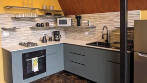 A modern kitchen with a gas stove, microwave, coffee maker, and a sink.