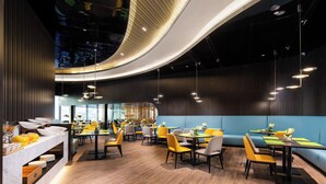 A modern restaurant with a curved ceiling, wooden flooring, and yellow and grey seating. - Hampton by Hilton Beijing Wangjing (Beijing)