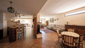 Amplia sala de estar con una mesa de comedor, sillas, un sofá y un televisor.