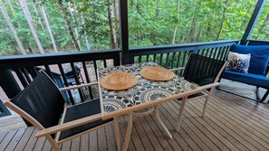 A covered outdoor seating area with a table and chairs, surrounded by a wooden deck and a railing. - Newly Renovated Cabin On 18 Acres Near State Parks, Trails, and Waterfalls (Coalmont)