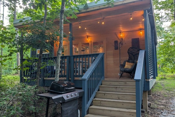 Front view of the Scandinavian Cabin at golden hour, with the porch lit.
