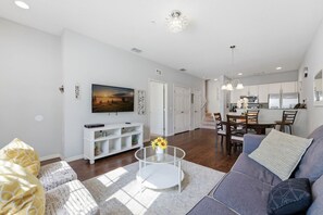 Een moderne woonkamer met een bank, salontafel en een schilderij aan de muur.