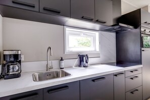 Eine moderne Küche mit integriertem Fenster, Edelstahlgeräten und einem eleganten Design.