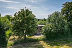 A secluded outdoor area with a wooden structure, a bench, and a fenced pathway. - Lodge 79 | 6 persoons chalet in Zennewijnen (Zennewijnen)