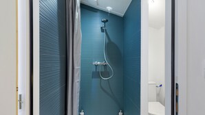 A modern bathroom with a shower, toilet, and sink.