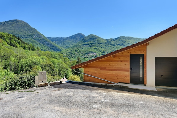 A modern building with a sloped roof, a wooden exterior, and a black door.