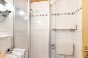 Un baño con ducha, inodoro y lavamanos.