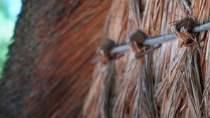 A close-up of a textured surface with a pattern of intertwined elements and a metallic bar.