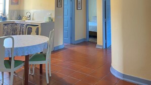 A spacious kitchen with a dining area, a bedroom with a bed, and a bathroom with a shower. - 2 bedroom house in the heart of the Serra d'Aire e Candeeiros natural park (Rio Maior)