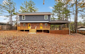 A two-story house with a covered porch and a brick foundation. - Marvelous Townhome + Car Charger & Near Events (Atlanta)
