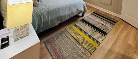 Un dormitorio con cama, escritorio, ventilador de techo, televisor y ventana con persianas.