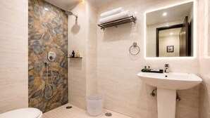 A bathroom with a shower, toilet, sink, and a mirror. - OPO ALPINE TREE (New Delhi)