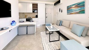 A modern apartment with a kitchenette, a dining area, a sofa, and a TV. - Appartement Nejma 2 Bedrooms (Sidi Bou Said)