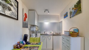 A compact kitchen with a dining area, a refrigerator, and a sink.
