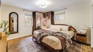 A bedroom with a bed, a nightstand, a mirror, and a window. - Stunning fall foliage views with EV charger close to Cooperstown (Sharon Springs)