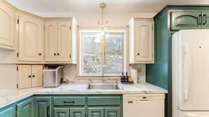 A kitchen with white cabinets, a green countertop, a sink, a dishwasher, and a refrigerator. - Stunning fall foliage views with EV charger close to Cooperstown (Sharon Springs)
