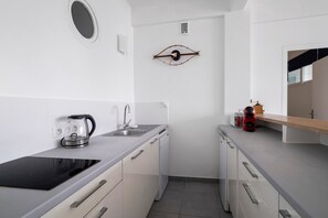 Eine moderne Küche mit Einbauherd, Kaffeemaschine und Geschirrspüler.