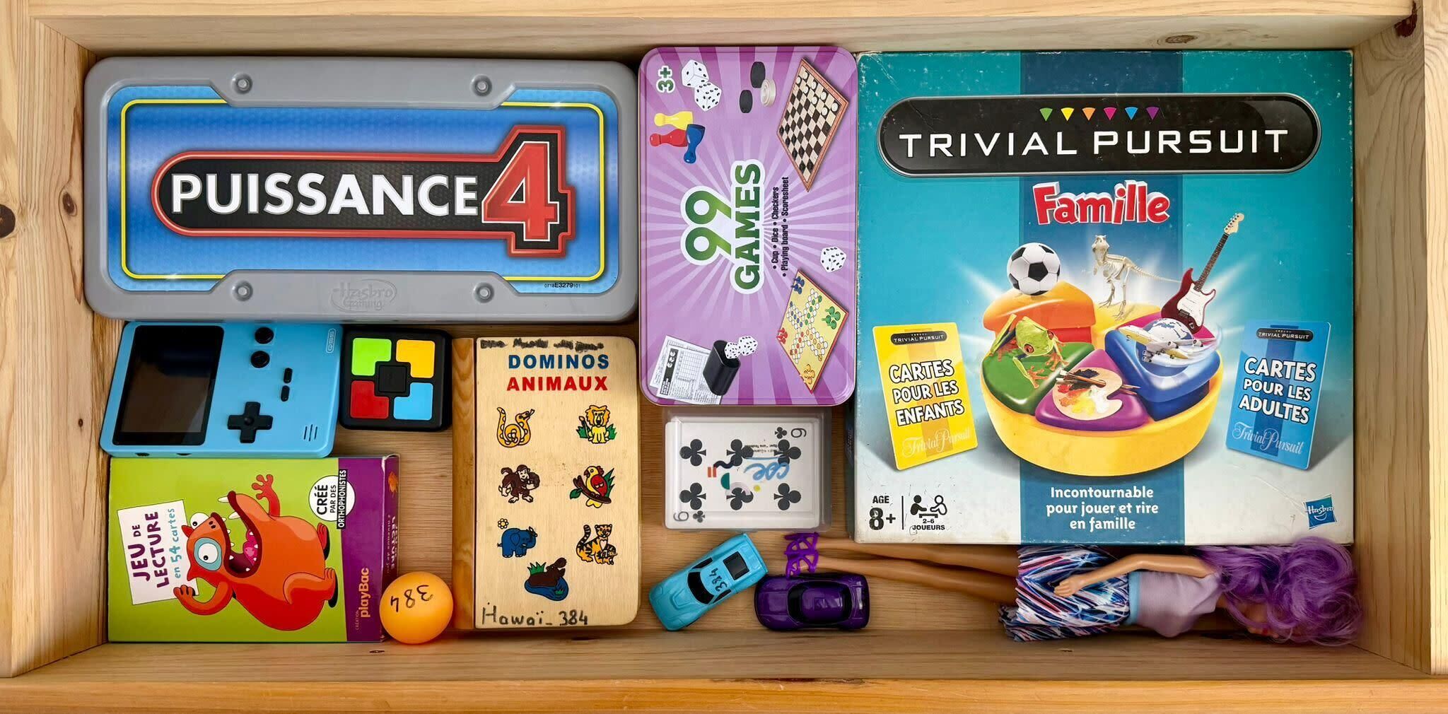 Uma caixa de madeira com diversos jogos de tabuleiro e brinquedos.
