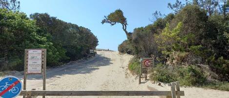 A sandy beach path with signs indicating 'BAINES' and 'COURANT D'ENGRASSON'.