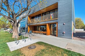 Un edificio moderno con un gran árbol en primer plano, un letrero que dice 'La Pasa Coffee' y una entrada visible.