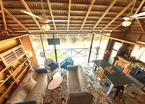A spacious room with a high ceiling, a dining area, a kitchen, and a seating area with a patterned floor. - Casa Brisa 2BR Treehouse Villa w/Pool-Breezy Open-Air Balcony in ProCab Cabarete (Cabarete)