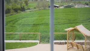 Een uitzicht op een groen veld met een houten constructie en een metalen hek.