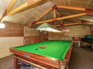 A pool table in a room with wooden walls and a sloped ceiling. - Stanbridge Cottage (Malmesbury)