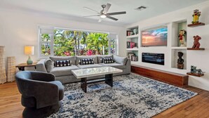 A living room with a sofa, armchair, coffee table, and a TV on the wall. - 3BR + Private Pool | Near Beach & Downtown (Delray Beach)