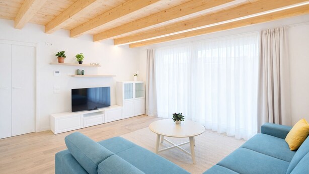 Una sala de estar moderna con televisor, sofá y mesa de centro.