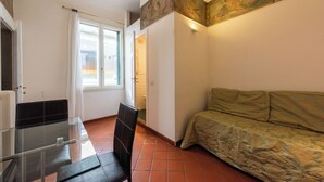 A room with a glass table, a black chair, a sofa, a door, and a window. - Fossi Panoramic Terrace by MMega (Florence)
