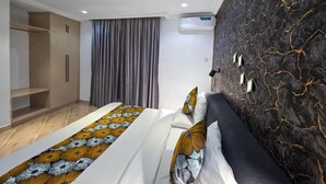 Un dormitorio moderno con cama, armario y equipo de aire acondicionado.