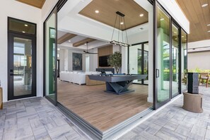 A modern interior with a pool table, a sofa, and a dining area. - New! Luxury Cape Coral Villa w/ Pool, Spa & Dock (Cape Coral)