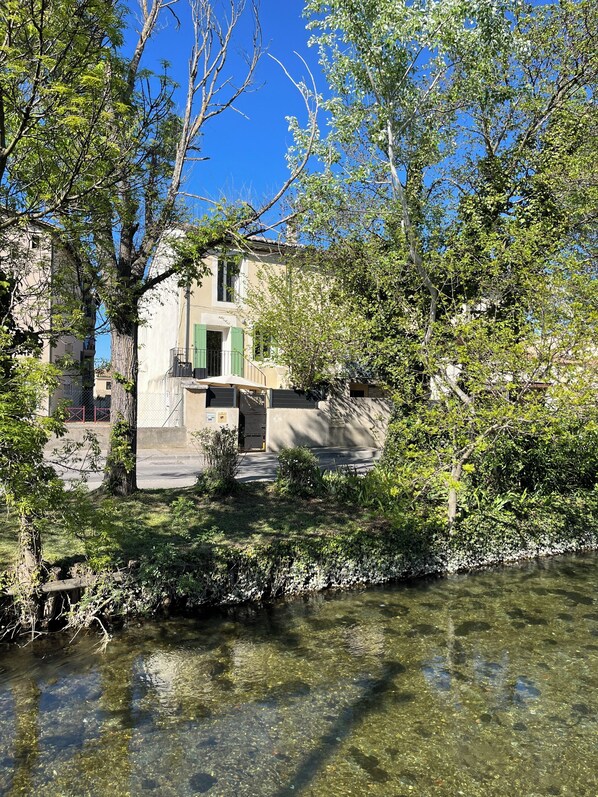 Un bâtiment offrant une vue dégagée sur une rivière, entouré d’arbres et de verdure.