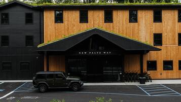 A building with a black and wooden facade, a black awning, and a sign reading 'NEW PALTZ WAY'.