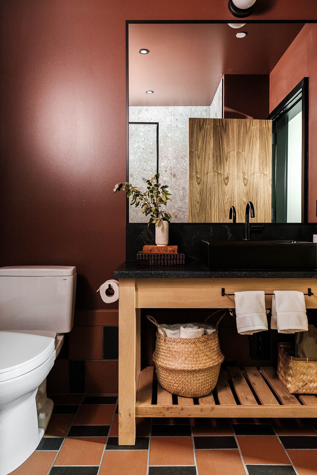 A modern bathroom with a toilet, sink, and mirror.
