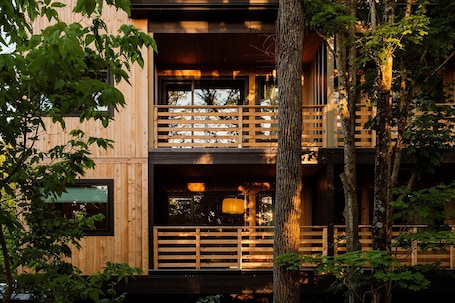 A multi-story wooden building with balconies and large windows.. New Paltz Way Hotel