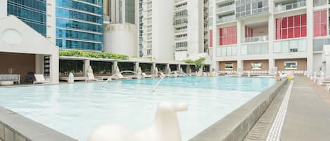 Una piscina interior con sillones de descanso y una gran escultura blanca al frente.