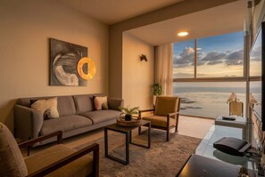 A modern living room with a sofa, armchair, coffee table, and a large window offering a view of the sea. - 21A, Apto 2 recamaras, vista al Mar (Panamá)