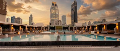 Un área de piscina en la azotea con un horizonte urbano de fondo.