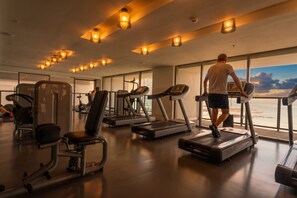 A gym with treadmills, exercise machines, and large windows offering a view. - Apartamento 14J en YOO, Vista al mar con 2 recámaras (Panamá)