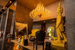 A luxurious lobby with a grand chandelier, a large mirror, and a statue. - Apartamento 14J en YOO, Vista al mar con 2 recámaras (Panamá)